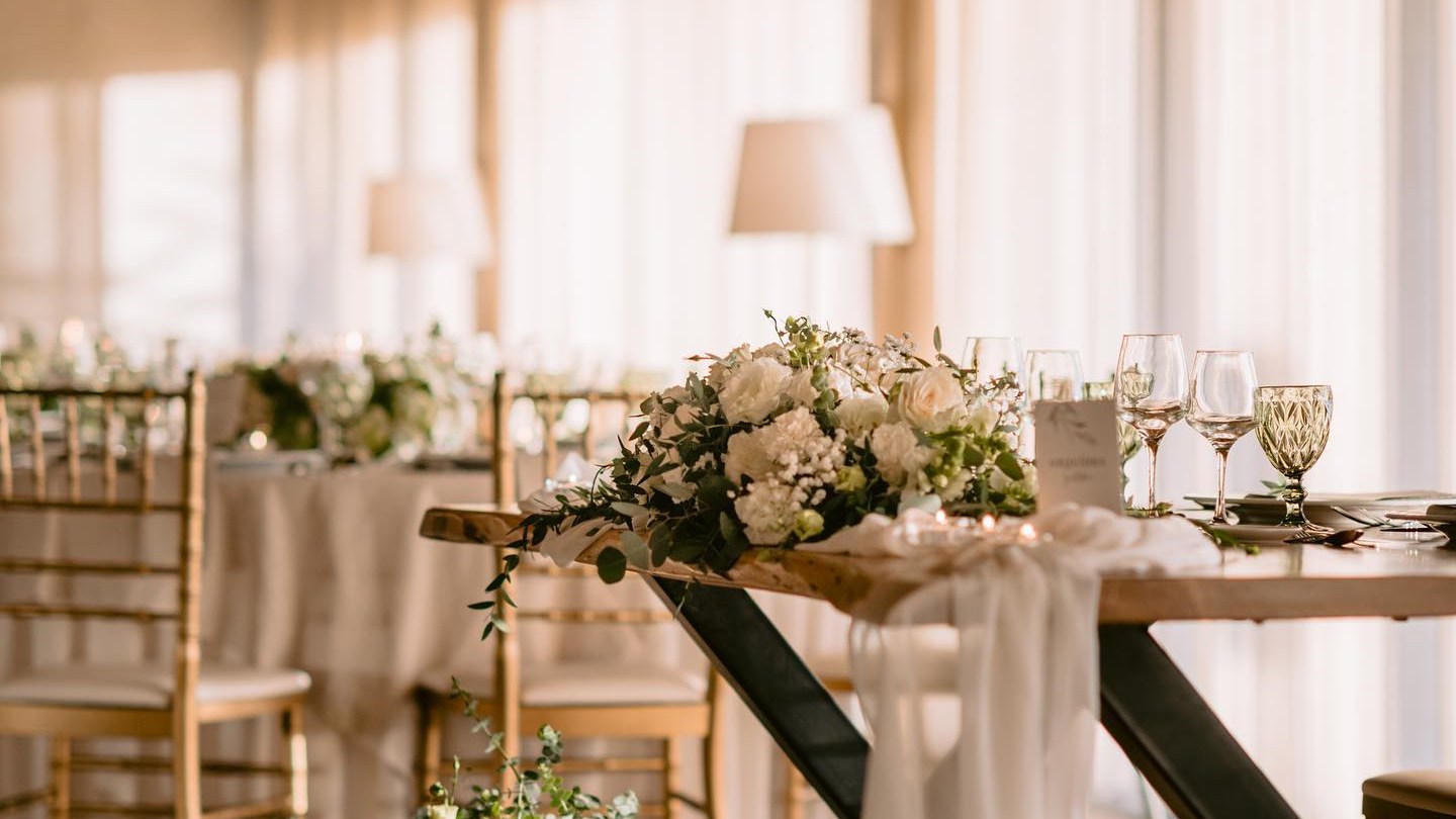 Mesa decorada com flores brancas no salão da Quinta do Alferes